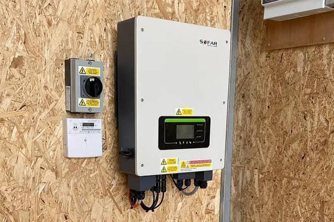 A pure sine wave inverter mounted on a wall next to the meter